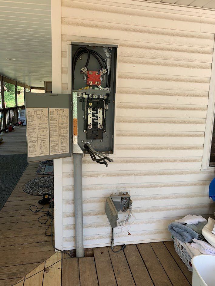 Old 200-amp service panel opened up on a covered porch