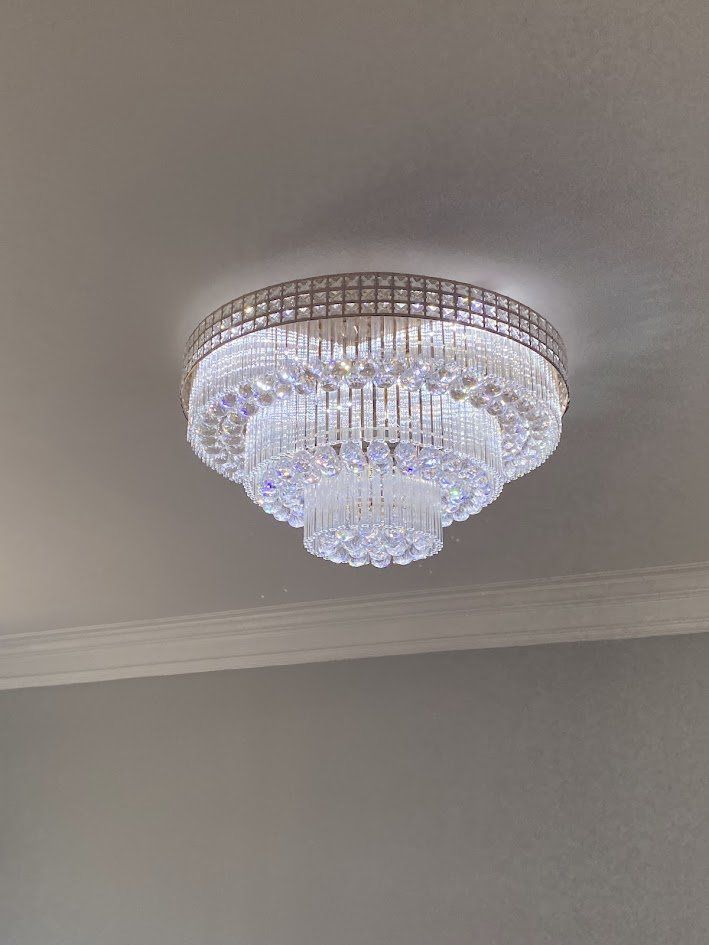 Tiered crystal flush-mount light fixture on the ceiling