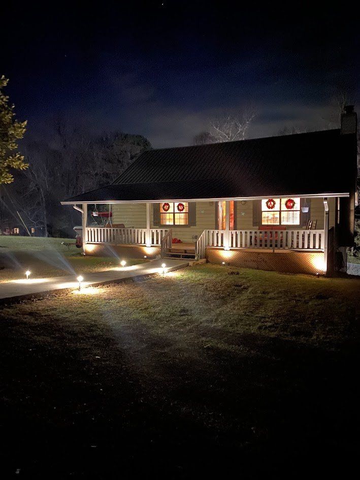 Front porch and walkway lit by low-voltage landscape lighting at night