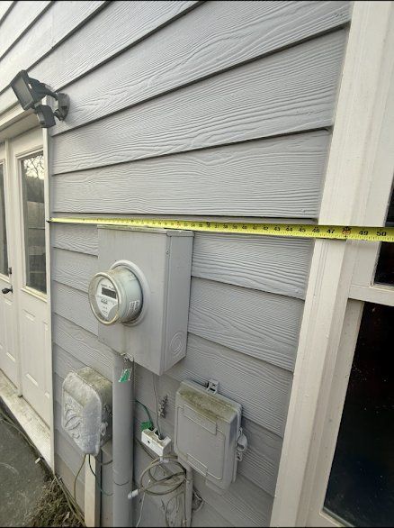 Old meter and service equipment on siding, measured for the new layout